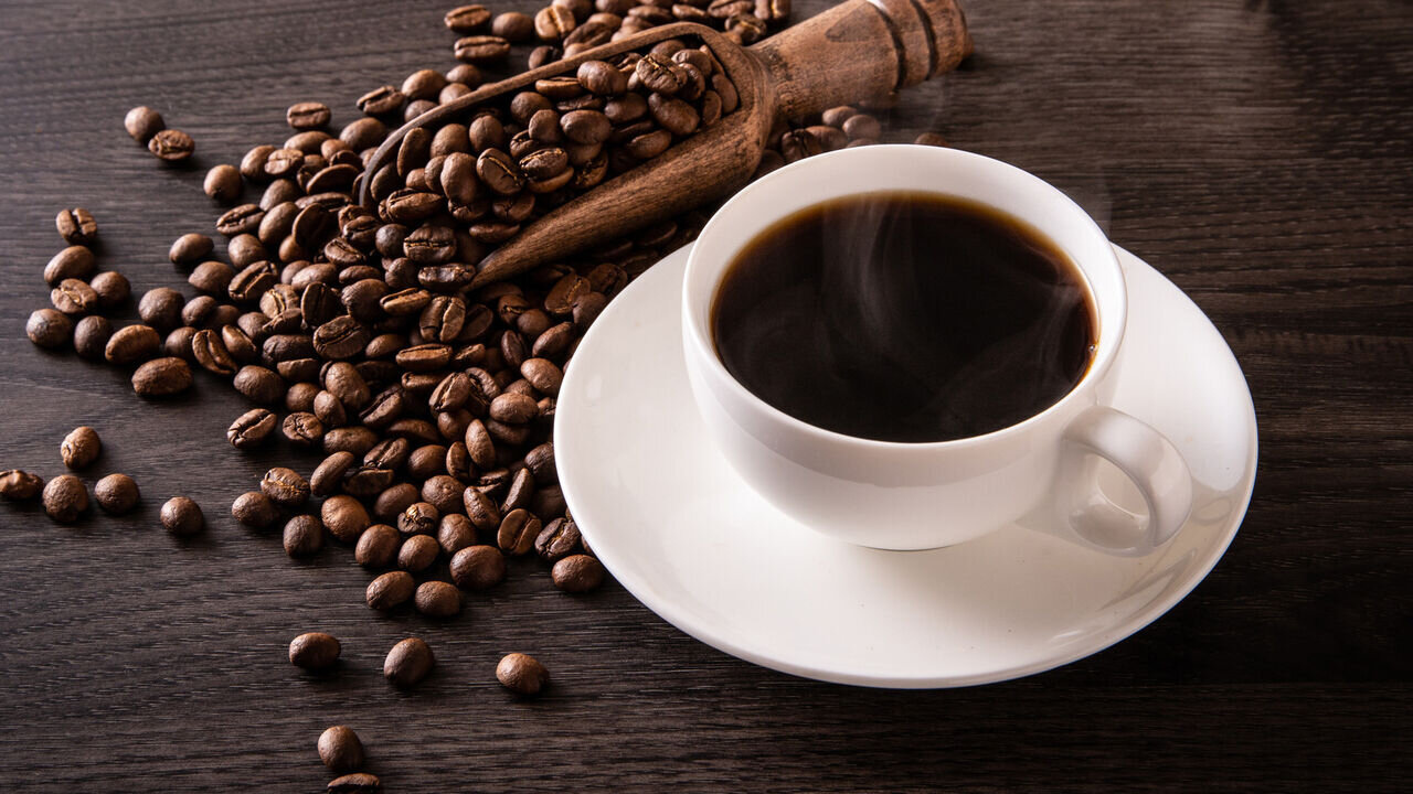 عکسی از دونه های قهوه و فنجان قهوه 