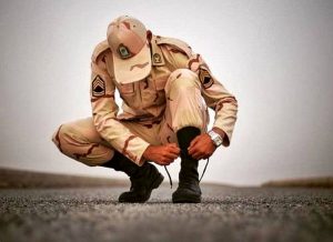 عکسی از سربازی که دارد پوتین خود را میپوشد