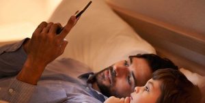 عکسی از پدر و دختری که به صفحه گوشی نگاه میکنند